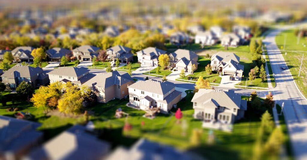 pexels-photo-1546168-1546168 Tilt-shift aerial photo of a suburban neighborhood with green lawns and roads.
